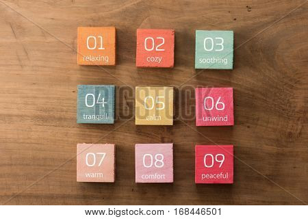 Terms for a relaxing service on hand painted colored wooden cubes on grungy wooden background with wooden taste. 