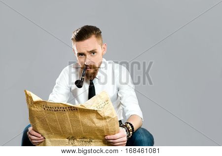 stylish the guy with the beard reads old newspaper