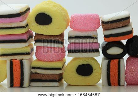 Stacked liquorice allsorts in different shapes colors and sizes