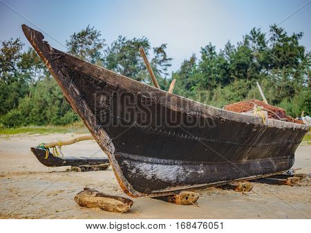 Traditional fishing boat on palm trees background Cavelossim Beach in South Goa, India