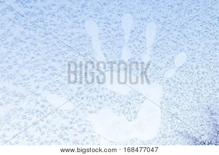 Handprint on a frozen window with snowflakes at -5 Celsius degrees. Winter at the Krasnodar, south Russia.