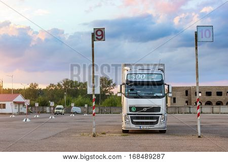Narva Estonia - August 20 2016: Volvo heavy truck loaded with goods trailer parked in waiting area on Estonian-Russian state border crossing. International hard transportation and logistics. Transport infrastructure