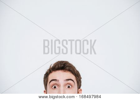 Man peeking out from the edge and looking at camera isolated on a white background
