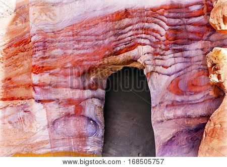 Rose Red Rock Tomb Arch Petra Jordan. Built by the Nabataens in 200 BC to 400 AD. Rose Red canyon walls create many abstracts close up. Inside the Tombs the rose red can become blood red. Reds are created by magnesium in sandstone.