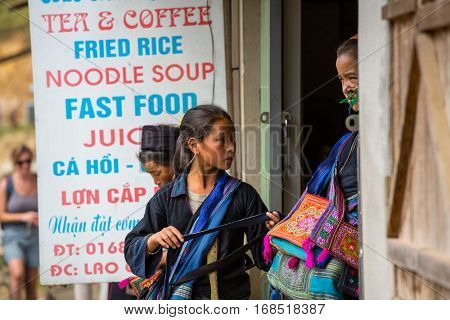 SAPA, VIETNAM - OCTOBER 29, 2012: Hmong women sell souvenirs in Sapa. The Hmongs are known for their colorful clothes and silver jewelry. Hmong women have various clothes colours and style