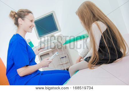 Preparing Girl To Ultrasonography. Medical Staff with Little Caucasian Girl in the Ultrasonography Hospital Room.
