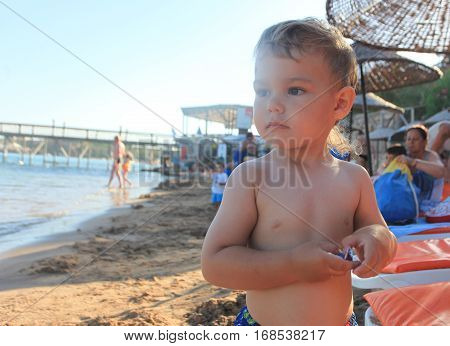 DIDIM TURKEY - JULY 9 2014. Baby boy playing with toys on the sea.
