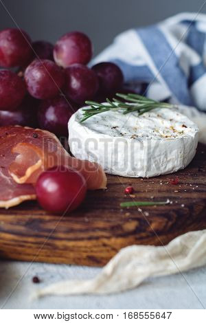 Camambert cheese, wine and cured meat. Appetizers for wine. Closeup view, selective focus