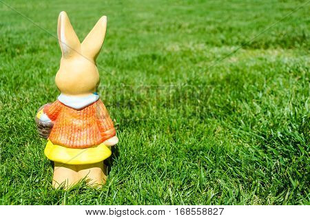 Easter bunny waith basket and color eggs in field - American landscape