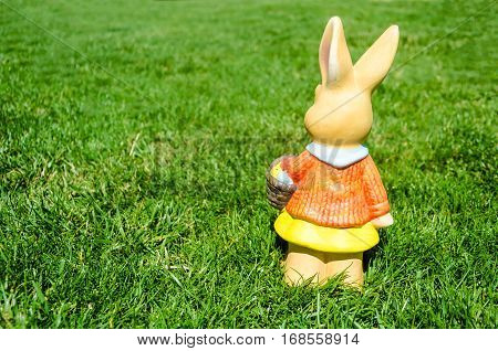 Easter bunny waith basket and color eggs in field - American landscape