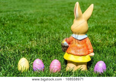 Easter bunny waith basket and color eggs in field - American landscape