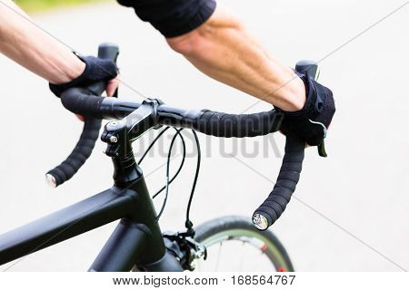 Sport man having Hands on handlebar of racing bike, drop bars, detail