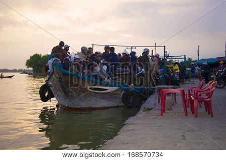 HOI AN, VIETNAM - JANUARY 02, 2016: The overloaded river ferry in evening twilight on the Thu Bon river