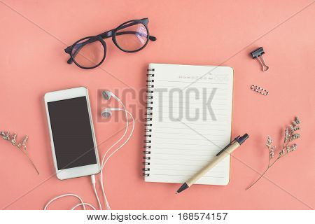Blank notebook with cellphone on color background in workspace with copy space Top view