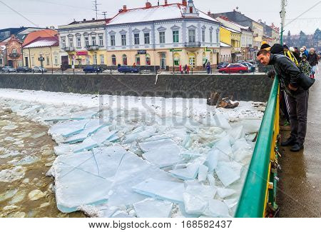 Uzhgorod Ukraine - February 3 2017: A man from the bridge watching the ice drift on the river.