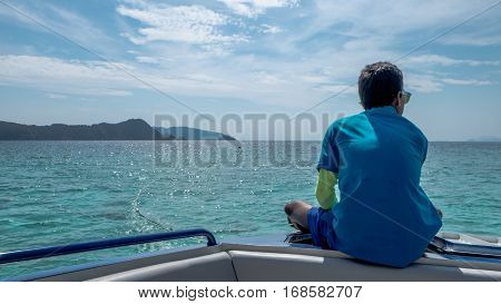 A man sitting lonely on boat and looking