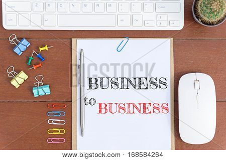 Text Business to business on white paper which has keyboard mouse pen and office equipment on wood background / business concept.