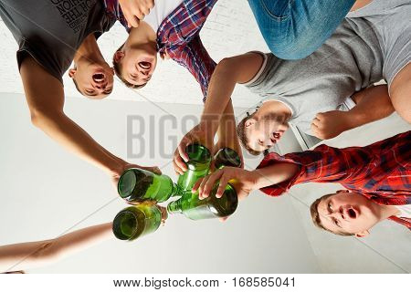 Bottom view friends with a bottle of beer in his hand screaming fun. The concept of male friendship.