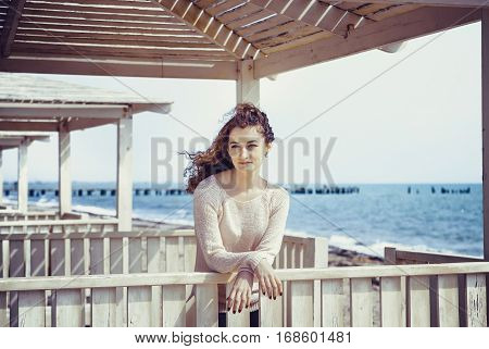 Curly girl smiling with happiness in a sunny alcove close-up
