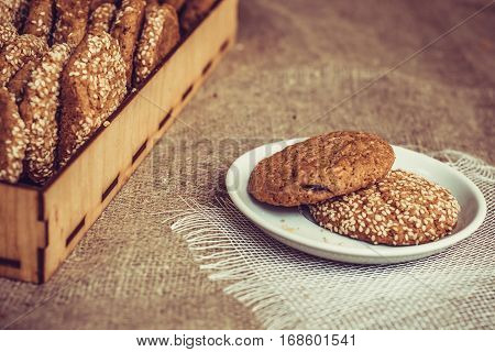 Biscuits with sesame seeds on a plate and a tray