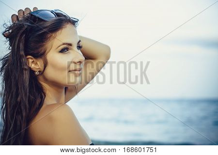 Girl brunette close-up on a background of water