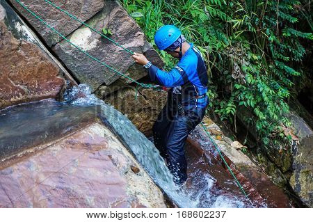 Beaufort,Sabah,Malaysia-Jan 28,2017:Adventure man rappelling Jempangah waterfall in Beaufort,Sabah,Borneo.Waterfall Abseiling activity adventure getting famous in Sabah,Borneo,Malaysia