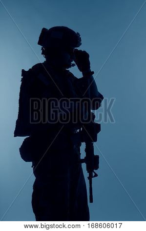 United states Marine Corps special operations command Marsoc raider with weapon. Silhouette of of Marine Special Operator blue background