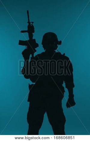 United states Marine Corps special operations command Marsoc raider with weapon. Silhouette of of Marine Special Operator blue background