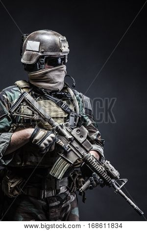 United states Marine Corps special operations command Marsoc raider with weapon. Studio shot of Marine Special Operator half-turning black background