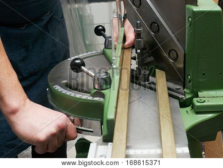 Craftsman working on frame in frameshop. Professional framer hand holding frame angle. Top view.
