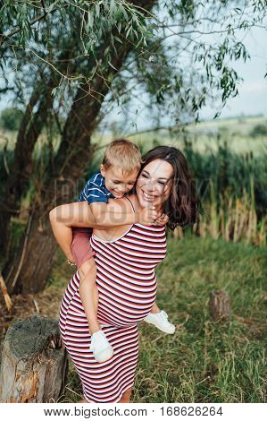 Pregnant Woman Hugging With Her Son.