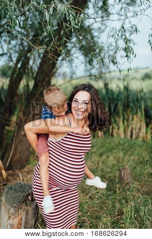 Pregnant Woman Hugging With Her Son.