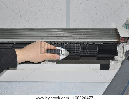 Close up on Air Conditioner Cleaning with Brush. Worker hand Air Conditioner Cleaning.