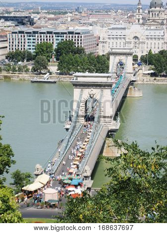 The Széchenyi Chain Bridge is a suspension bridge that spans Danube river between Buda and Pest, western and eastern parts of Budapest city, the capital of Hungary.