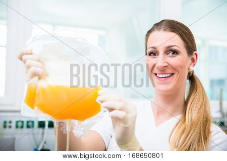 Doctors assistant at blood donation service with plasma donation in blood bag