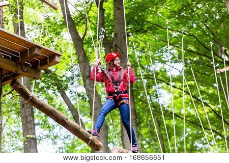 Child reaching platform climbing in high rope course