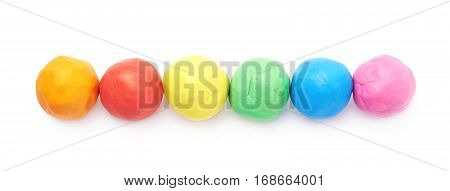 Multiple colorful plasticine balls arranged in a line, composition isolated over the white background