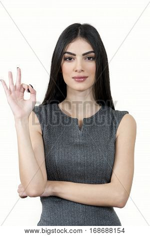 Young business woman looking at the camera and doing the ok sign.