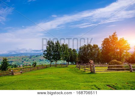 A Wide Angle View of a Wooden Fence Under a Blue Sky with a Beautiful Meadow Blanketed with Wildflowers.