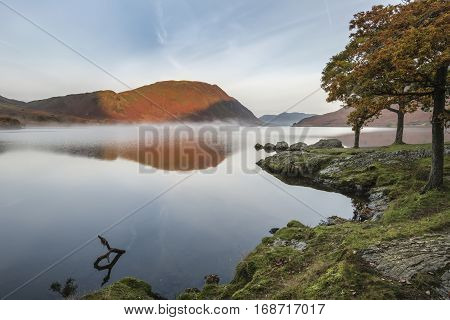 Beautiful Autumn Fall Landscape Image Of Crummock Water At Sunrise In Lake District England