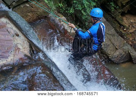Beaufort,Sabah,Malaysia-Jan 28,2017:Adventure man rappelling Jempangah waterfall in Beaufort,Sabah,Borneo.Waterfall Abseiling activity adventure getting famous in Sabah,Borneo,Malaysia