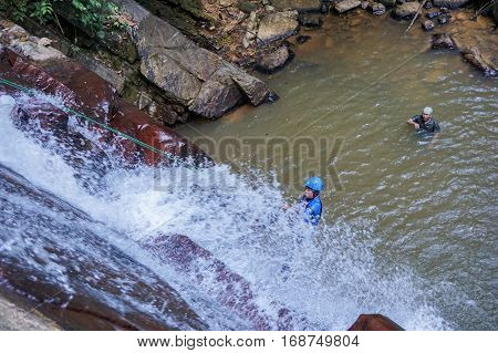 Beaufort,Sabah,Malaysia-Jan 28,2017:Group of adventurer rappelling in Jempangah waterfall at Beaufort,Sabah,Borneo.Waterfall Abseiling activity adventure getting famous in Sabah,Borneo,Malaysia