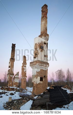 The furnace and the tubes of the ashes of the burned house at sunset. Russia