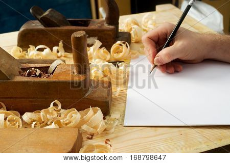 White sheet on wooden table for carpenter tools with sawdust. Copy space. Top view.