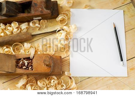 White sheet on wooden table for carpenter tools with sawdust. Copy space. Top view.