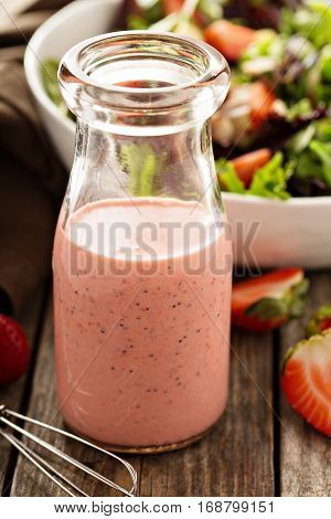 Strawberry poppy seed salad dressing in a glass bottle