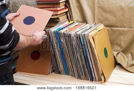 Retro styled image of a collection of old vinyl record lp's with sleeves on a wooden background. Top view. Copy space.