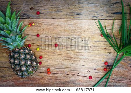 Pineapple, Raw Coffee Beans And Grass. On Wooden Rustic Background Top View Borde.