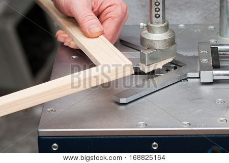 Craftsman working on frame in frame shop. Professional framer hand holding frame angle. Top view.