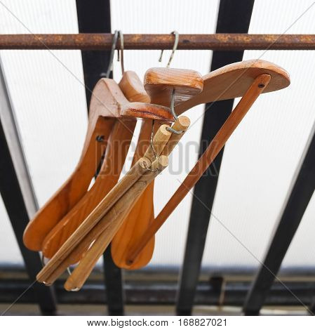 Wooden Coat Hangers Hanging on Old Rustic Clothes Rack.